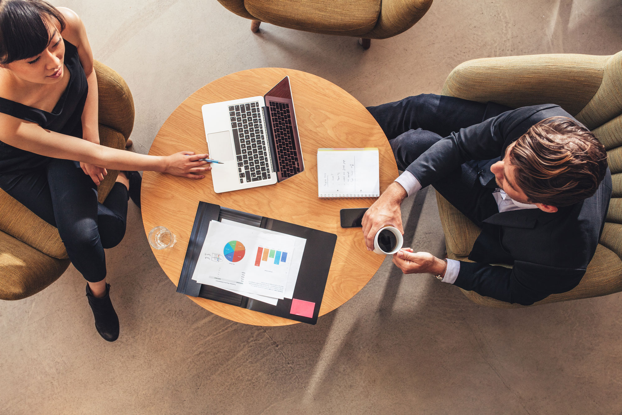 Top view of two people sitting at a coffee table talking